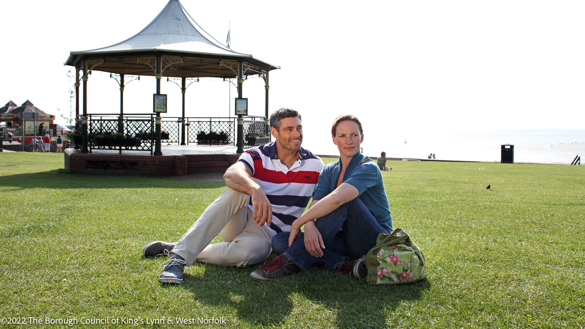 Couple sitting on grass in Hunstanton