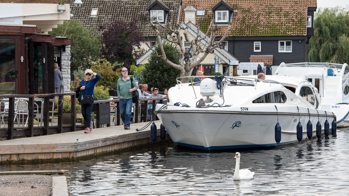 people and boats on river bank